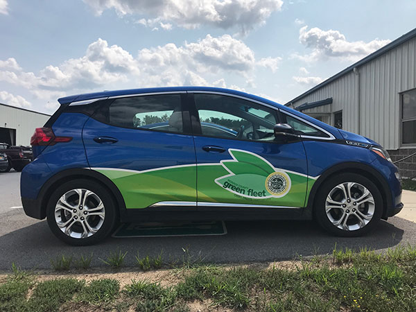 All electric vehicle, Chevrolet Bolt, with Monroe County Green Fleet logo on door