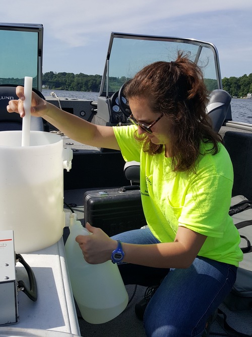 Photo of lady on a boat testing water