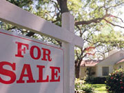 Picture of For Sale sign in front of house.