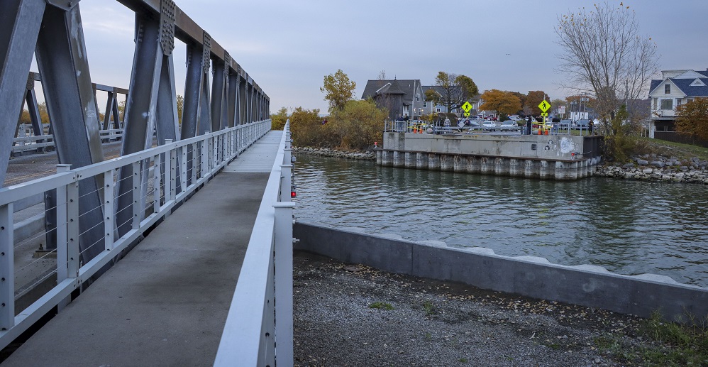 Photograph of a bridge towards a horizon above water