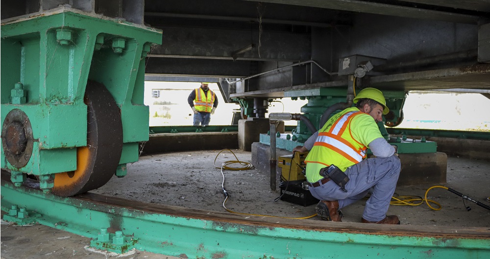 Photo of a construction worker using "Swing bridge machinery"