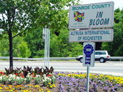 Picture of flowers underneath Monroe County In Bloom sign.