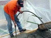 Picture of crew member pouring concrete.