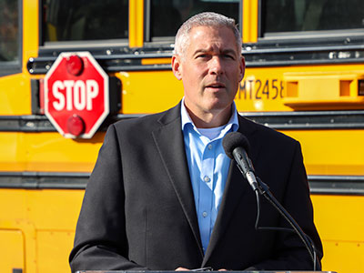 Adam Bello in Front of School Bus