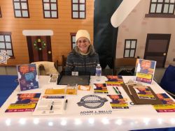 Photo of lady sitting in from of Rochester Village Display